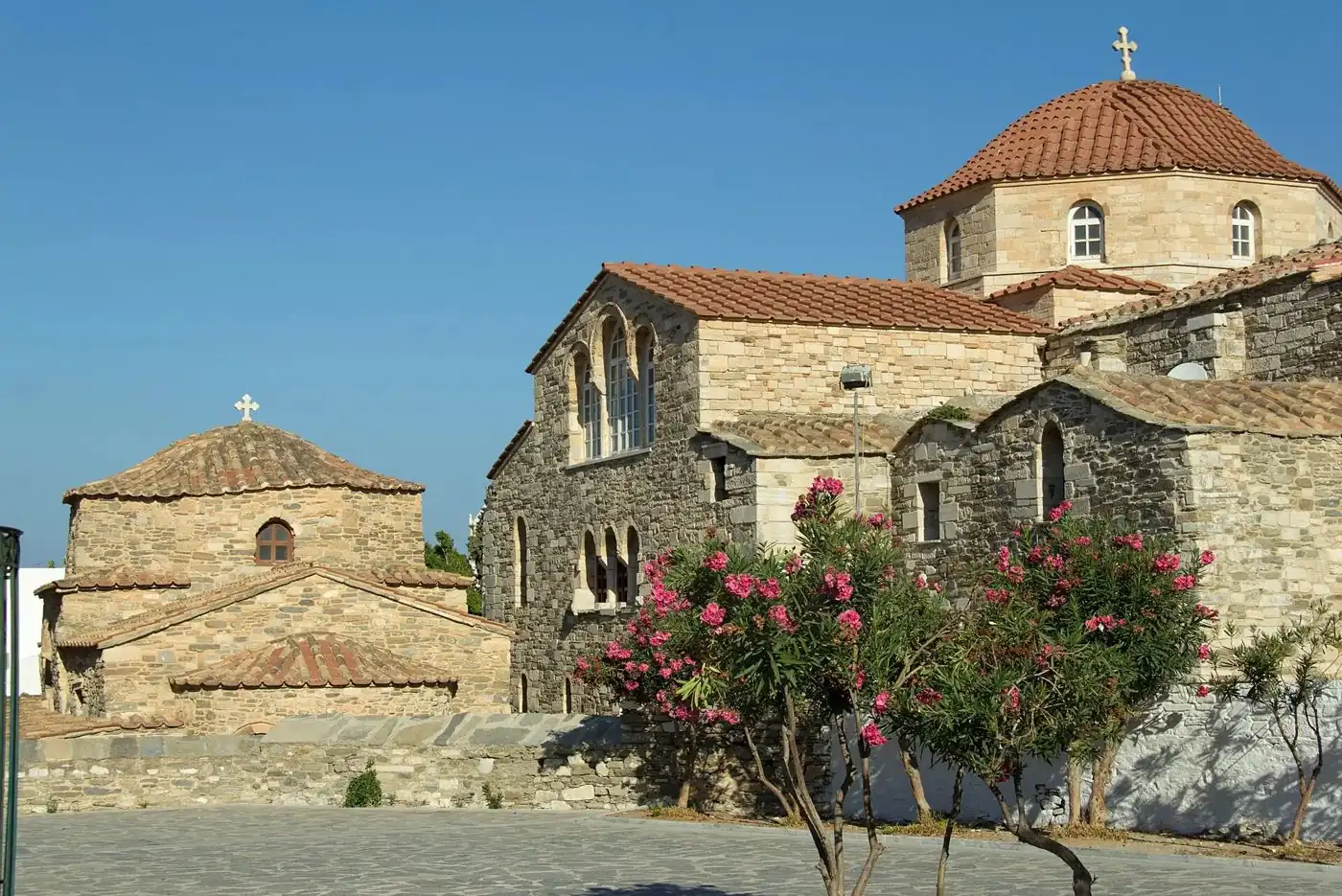 La chiesa in pietra della Panagia Ekatontapyliani a Parikia, Paros, tra oleandri e cupole coperte di tegole